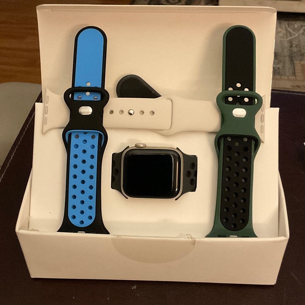 Apple Smartwatch with multiple bands and charger cords.